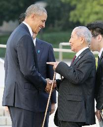 <p>　２０１６年５月、現職の米大統領として初めて広島を訪れたオバマ氏（左）と握手する被団協の坪井直代表委員＝広島市の平和記念公園</p>