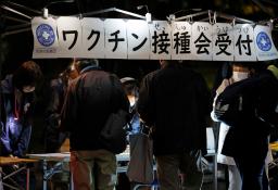 <p>　路上生活者らに向け行われた新型コロナワクチン集団接種で、受け付けをする人たち＝３０日夜、東京都豊島区</p>
