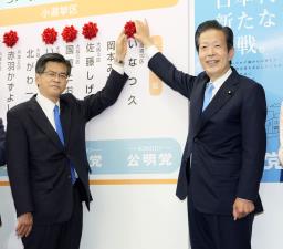 <p>　公明党の開票センターで当確者の名前に花を付ける山口代表（右）と石井幹事長＝３１日午後１１時１分、東京都新宿区の党本部</p>