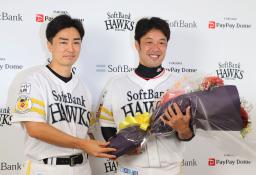 <p>　引退の記者会見で、和田（左）から花束を受け取り笑顔のソフトバンク・高谷＝１日、ペイペイドーム</p>
