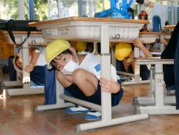 <p>　南海トラフ巨大地震を想定した防災訓練が行われた鹿児島県志布志市立香月小で、机の下に身を隠す児童＝５日午前</p>