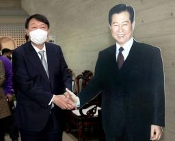<p>　１１日、韓国・木浦の金大中ノーベル平和賞記念館で金氏のパネル（右）と握手してみせる最大野党「国民の力」の尹錫悦前検事総長（聯合＝共同）</p>