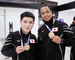 <p>　帰国して金メダルを見せる坪井智也（左）と岡沢セオン＝８日、成田空港</p>