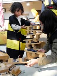 <p>　「ゲゲゲのゲタつみ大会」で、げたを積み上げる親子＝１４日午後、鳥取県境港市</p>