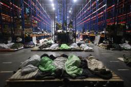 <p>　ポーランドとの国境に近いベラルーシ西部の倉庫で寝る難民ら＝２２日（ＡＰ＝共同）</p>