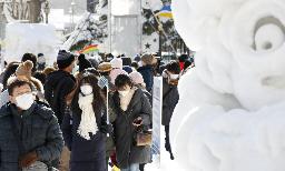 <p>　２０２０年２月に行われた「さっぽろ雪まつり」でマスク姿で会場を歩く人たち＝札幌大通公園</p>