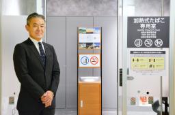 <p>　函館空港ビル内にある加熱式たばこ専用の喫煙所の前に立つ八島聡社長＝１日午前</p>
