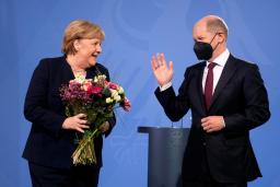 <p>　８日、ベルリンで、ショルツ新首相（右）から花束を受け取るメルケル前首相（ＡＰ＝共同）</p>