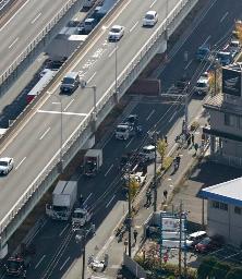 <p>　大型トラックなど２０台以上が絡んだ多重事故の現場（高架下の国道）＝１０日午前１１時２８分、愛知県小牧市（共同通信社ヘリから）</p>