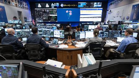 <p>　パラシュートを開いた宇宙船オリオンの着水を見守る管制担当者ら＝１０日、米テキサス州ヒューストンのジョンソン宇宙センター（ＮＡＳＡ提供）</p>
