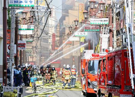 <p>　大阪市中央区の火災現場で、消火活動する消防隊員ら＝１８日午前８時３５分</p>