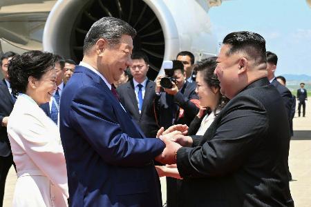 　平壌国際空港に到着した中国の習近平国家主席（手前左）を出迎える北朝鮮の金正恩朝鮮労働党総書記＝８日（新華社の「微博（ウェイボ）」から、共同）