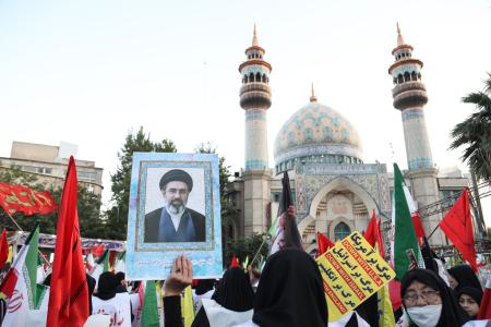 <p>　１２日、イラン・テヘランで最高指導者モジタバ・ハメネイ師を支持して国旗を持つ人たち（ゲッティ＝共同）</p>