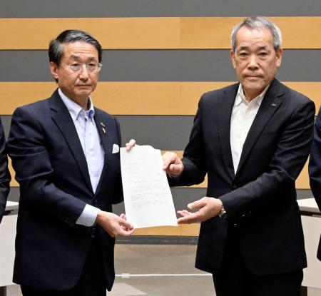 <p>　中国電力から島根原発２号機のプルサーマル発電についての文書を受け取る平井伸治鳥取県知事（左）＝２４日午前、鳥取県境港市</p>