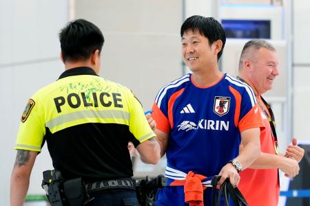 <p>　ヒューストンの空港に到着し、警察官の背中にサインした森保監督（右）＝１日（共同）</p>