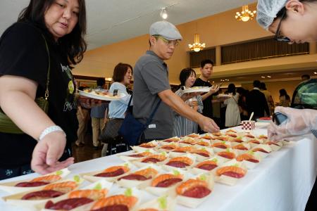 <p>　在中国日本大使館で振る舞われた寿司を楽しむ参加者＝２日、北京（共同）</p>