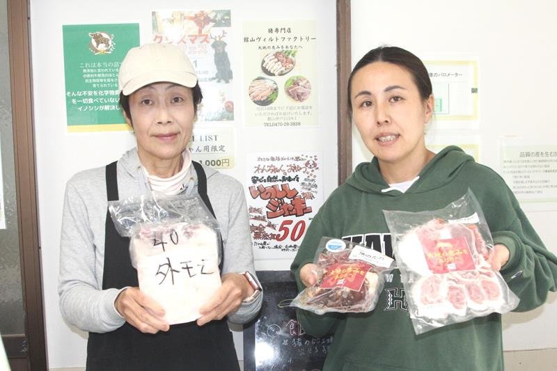 自ら解体し、商品化したイノシシの肉を見せる上田訓子さん(左)と梶山奈々さん=館山市