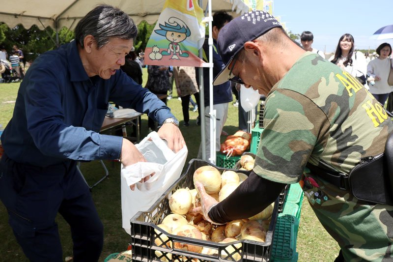 タマネギのつかみ取りに挑戦する男性(右)=10日、白子町