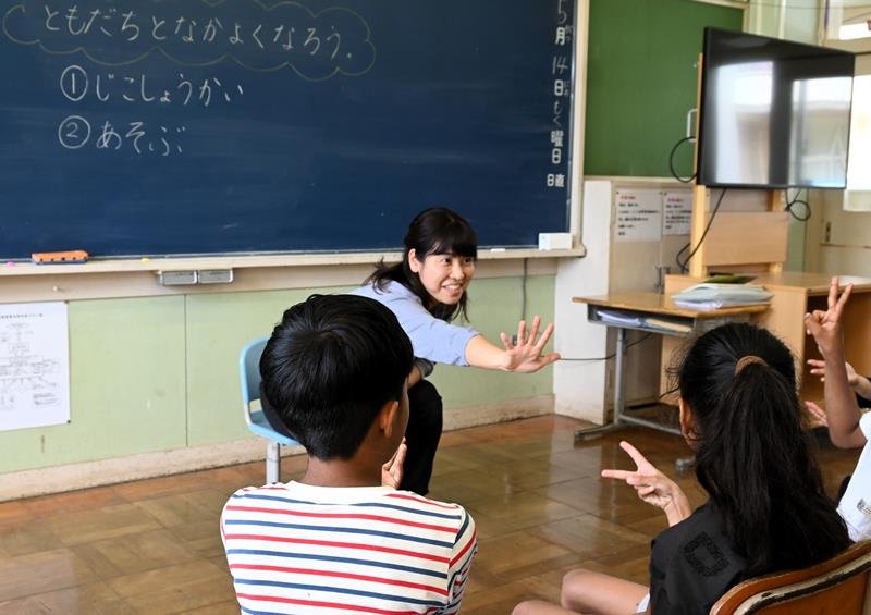 日本語指導が必要な児童2人(手前)にじゃんけんについて教える担当教諭=5月14日、富里市