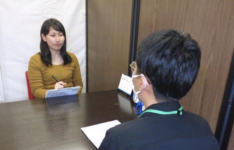 「ワーク・ダイバーシティ」事業のスタッフ（左）と話す岐阜市の男性＝４月、岐阜市（共同）