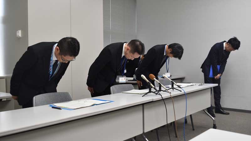 懲戒免職処分を発表し、頭を下げる伊澤浩二教育次長(中央)ら=10日、県庁