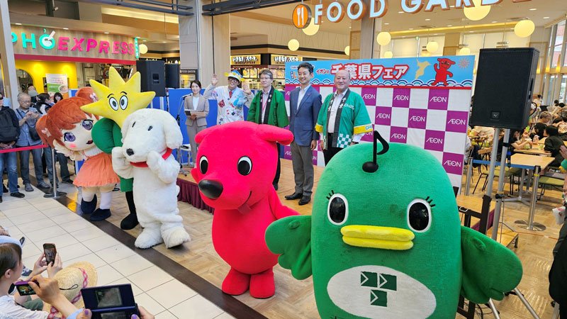 ご当地キャラとともに、県産食品をPRする熊谷知事(後列右から2人目)。セレモニーにはタレントで魚類学者のさかなクン(同4人目)も参加した=13日午後、習志野市
