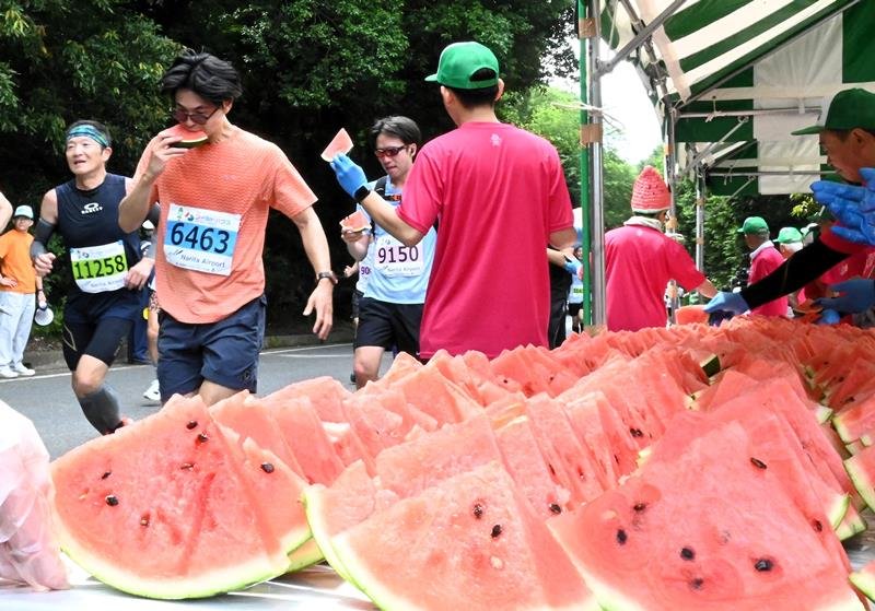 「給スイカ所」で特産のスイカを頬張るランナー=富里市