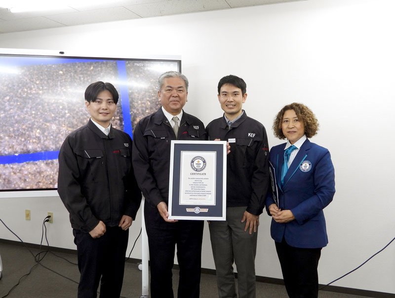 ギネス認定証を持つケーイーエフの伊与久義武社長(左から2人目)。左は次男の純平さん、右は長男の雅博さん=15日、佐倉市