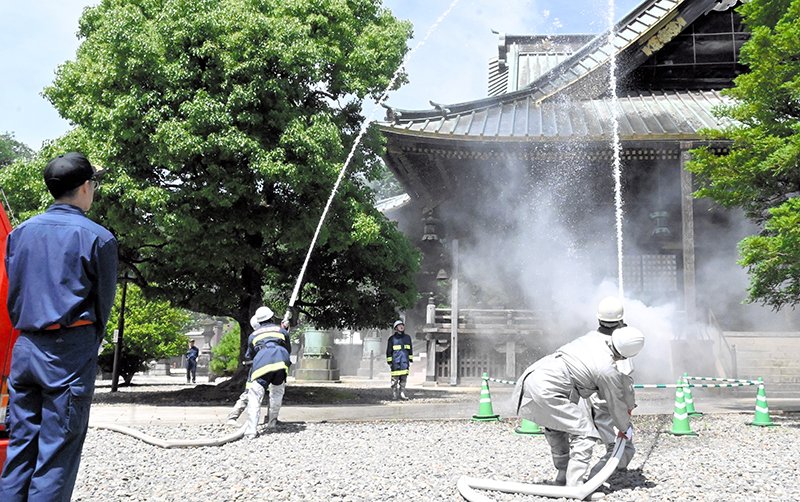 釈迦堂に放水する自衛消防隊員ら=16日、成田市の成田山新勝寺