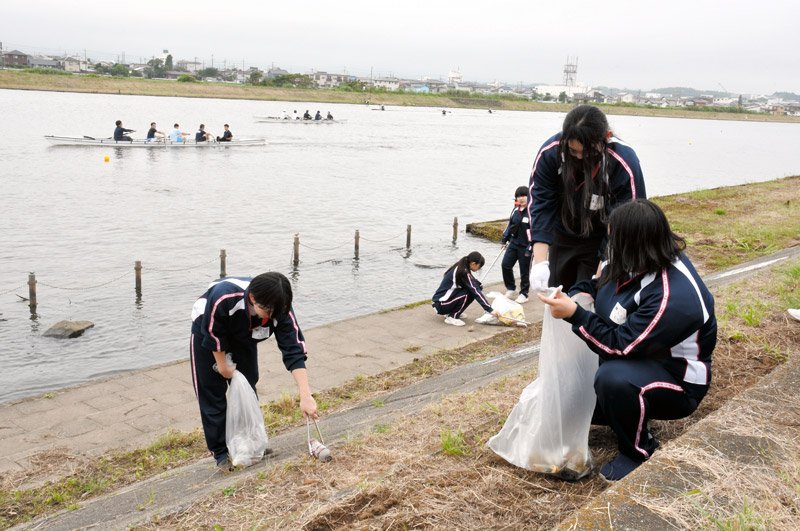 レガッタの練習が行われている黒部川でごみ拾いをする参加者ら=20日、香取市
