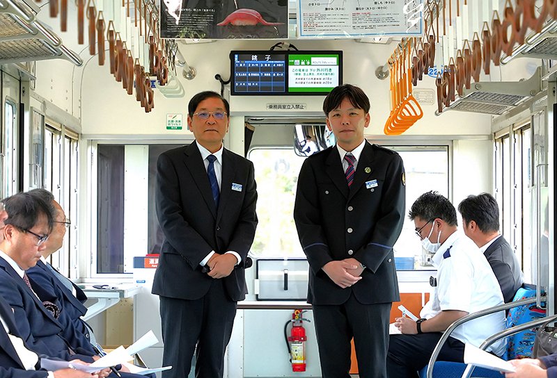 銚子電鉄社長に就任した西上氏（中央右）と会長となった竹本氏＝３０日、銚子市の電車内