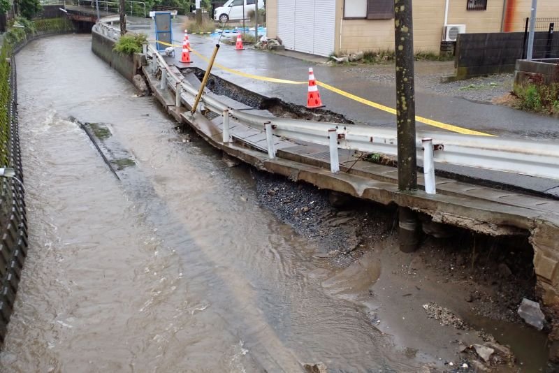 雨で水流が増した影響で崩落した川の護岸や道路の一部＝２７日午後０時２１分、銚子市本城町２
