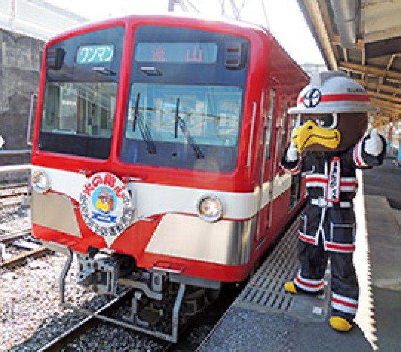 流鉄の車両前でポーズを取るおおたかくん＝５日、流山市の流鉄流山駅