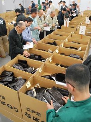 新ノリを手に取り品質を吟味する競りの参加者＝２７日、富津市