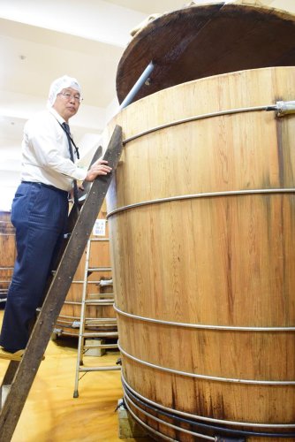 私市社長は長年木おけを使った醸造を続けている＝鎌ケ谷市
