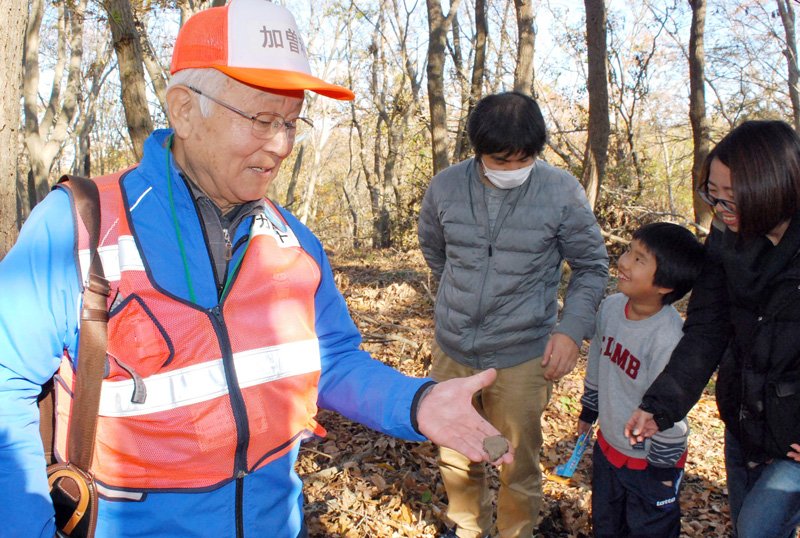 子どもが拾った縄文土器の破片を解説する加曽利貝塚ガイドの会のメンバー（左）＝昨年１２月８日、千葉市若葉区の同貝塚