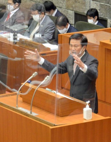 手振りを交え、アクアライン８００円化の運動を共にしてきた高橋浩県議への質問に答える森田千葉県知事＝９日、県議会本会議場