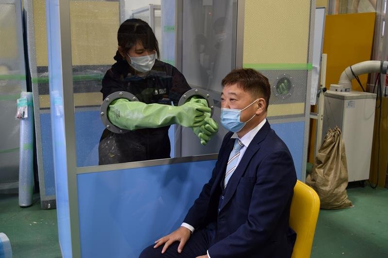 ＰＣＲ検査ボックスの使い方を実演する箕輪社長（右）＝千葉市美浜区
