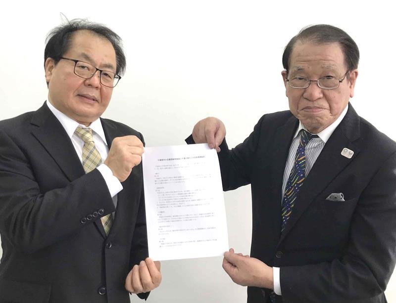 協定書を手にする平会長（右）と大澤社長＝千葉市中央区