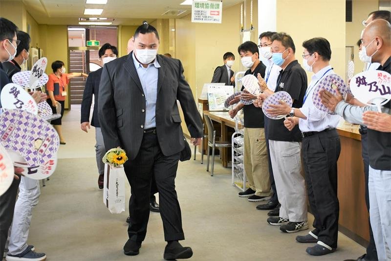 応援うちわを持った職員に歓迎される舛ノ山さん＝栄町役場