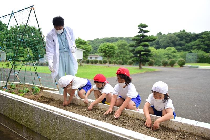 石橋さんの話を聞いて落花生を植える児童＝神崎町立米沢小
