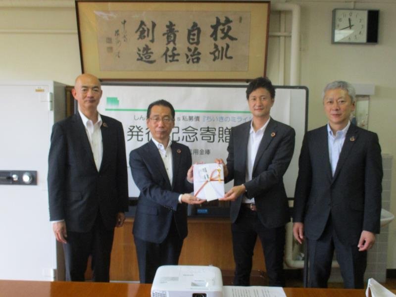 目録を手にする常世田校長（左から２人目）と柳田社長（同３人目）＝一宮町