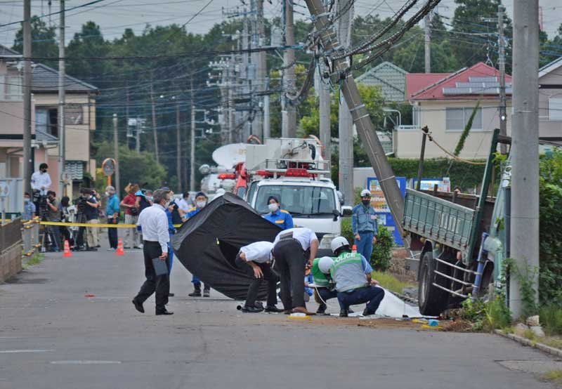 事故現場を調べる千葉県警の捜査員ら。右端のトラックが小学生らの列に突っ込んだとみられる＝２８日午後６時２５分ごろ、八街市八街は

