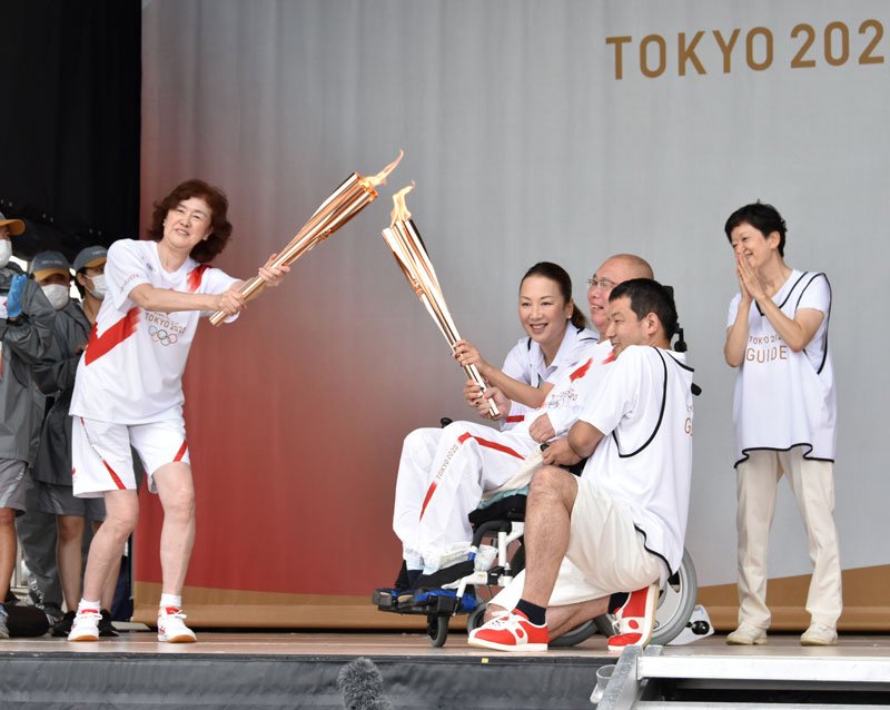 聖火リレーの代替イベントでトーチキスを行うランナーたち＝１日午後３時２０分ごろ、山武市の蓮沼海浜公園

