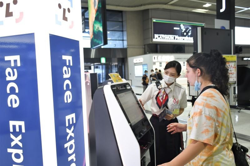 顔認証技術を活用した搭乗手続きシステムを利用する旅客＝１９日、成田空港第２ターミナル