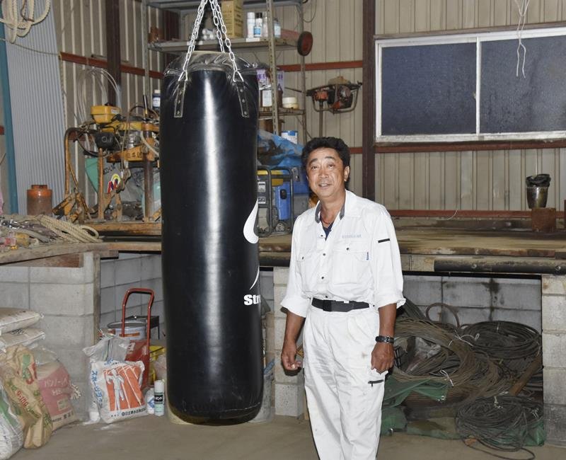 資材倉庫の練習で並木月海が使ったサンドバッグと大塚浩二さん＝６月、成田市（共同）
