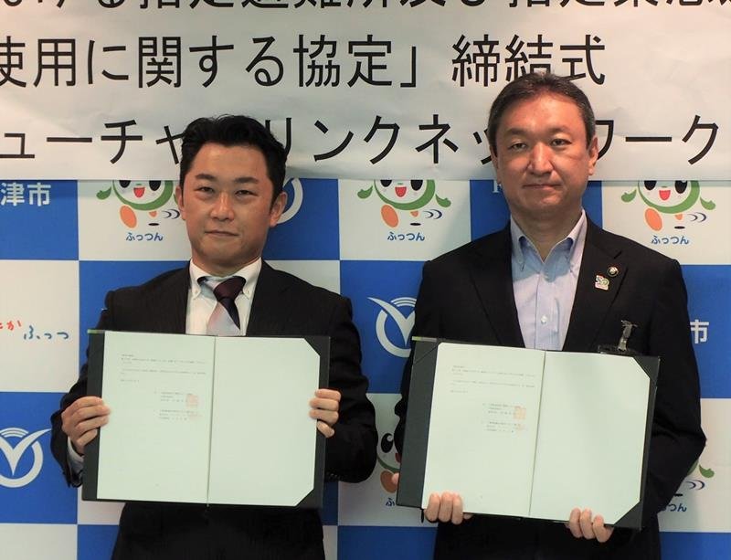 旧金谷小の利活用と災害時に避難所として利用するための協定を締結した高橋市長（右）と石井社長＝１６日、富津市
