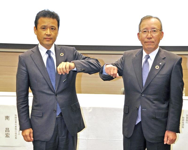 記者会見で撮影に応じる、りそなホールディングスの南昌宏社長（左）と京葉銀行の熊谷俊行頭取＝２４日午後、東京都内（共同）
