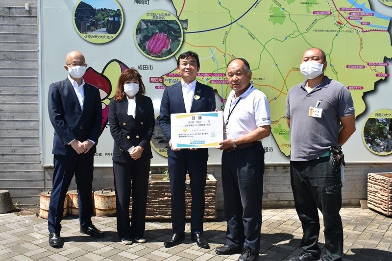 畔蒜代表取締役（右から２人目）に目録を手渡す細井支社長（中央）＝香取市