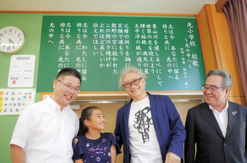 横芝光町立光小学校の校歌を作詞作曲した依知川さん（右から２人目）と児童会長の竹内さん（同３人目）。右は佐藤町長、左は石井校長＝同校